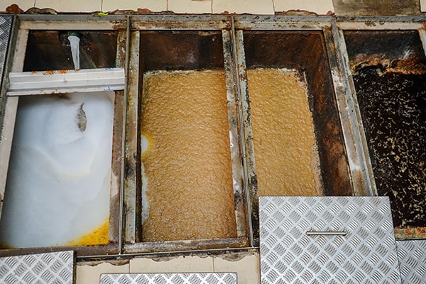 regular grease trap maintenance includes inspecting for foul odors and slow drainage